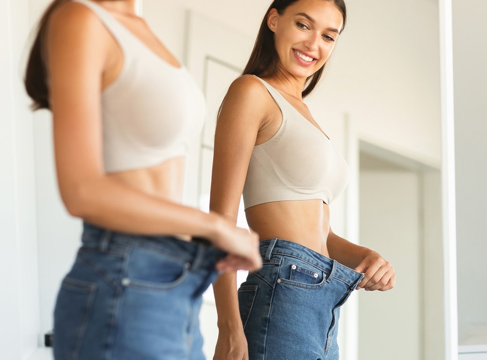 Woman looking in mirror at stomach